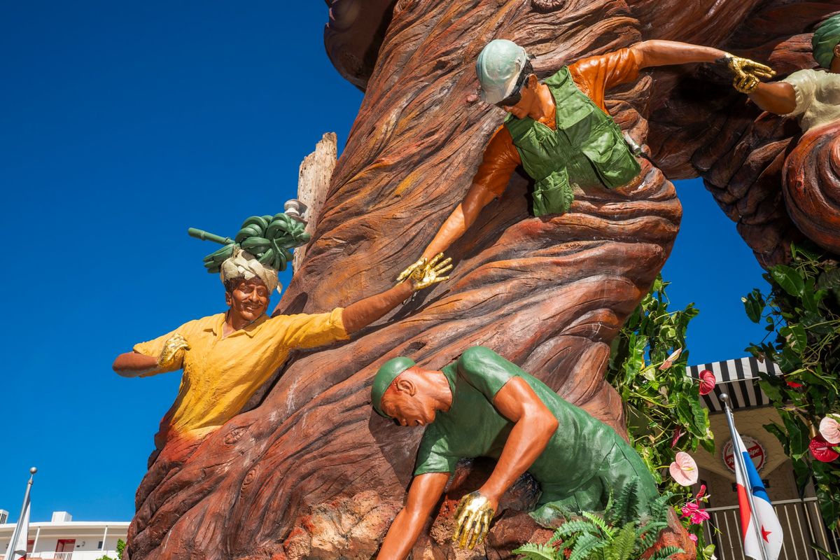 The farmer carrying bananas, the builder and the soldier, with a broken wooden light pole behind them
